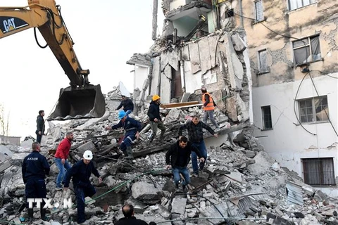 Lực lượng cứu hộ tìm kiếm nạn nhân dưới đống đổ nát sau động đất ở Thumane, cách thủ đô Tirana (Albania) 34km về phía Tây Bắc ngày 26/11/2019. (Nguồn: AFP/TTXVN) 