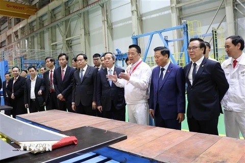 Trưởng Ban Kinh tế Trung ương Nguyễn Văn Bình cùng các đại biểu tham quan Nhà máy Sản xuất máy biến áp truyền tải 220-500 KV. (Ảnh: Đinh Văn Nhiều/TTXVN) 