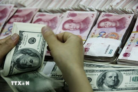 Đồng USD và đồng nhân dân tệ của Trung Quốc tại ngân hàng ở tỉnh An Huy. (Nguồn: AFP/TTXVN) 