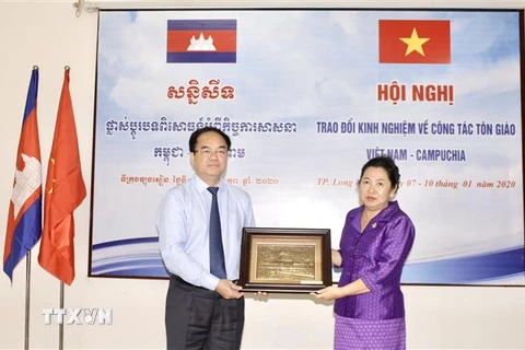 Ông Vũ Chiến Thắng, Trưởng Ban Tôn giáo Chính phủ tặng quà lưu niệm cho bà Min Chandyneth, Phó Quốc vụ khanh Bộ Lễ nghi và Tôn giáo Vương quốc Campuchia tại hội nghị. (Ảnh: Thanh Sang/TTXVN) 