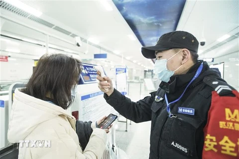 Nhân viên kiểm tra thân nhiệt của hành khách tại một nhà ga ở Vũ Hán, tỉnh Hồ Bắc, Trung Quốc ngày 23/1/2020. (Nguồn: THX/TTXVN) 