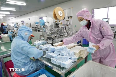 Công nhân nỗ lực may khẩu trang y tế tại một nhà máy ở Vũ Hán, Trung Quốc. (Nguồn: THX/TTXVN) 