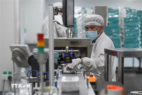 Công nhân làm việc tăng ca để sản xuất thuốc tại Công ty dược ở Hải Khẩu, tỉnh Hải Nam, Trung Quốc trong bối cảnh dịch viêm đường hô hấp cấp do virus corona chủng mới bùng phát, ngày 3/2/2020. (Nguồn: THX/TTXVN) 