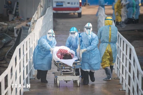 Nhân viên y tế chuyển bệnh nhân nhiễm COVID-19 tới bệnh viện dã chiến ở Vũ Hán, tỉnh Hồ Bắc, Trung Quốc, ngày 4/2/2020. (Nguồn: THX/TTXVN) 