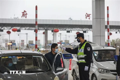 Kiểm tra thân nhiệt của lái xe trên tuyến đường cao tốc ở Vũ Hán, tỉnh Hồ Bắc, Trung Quốc, ngày 24/1. (Nguồn: AFP/TTXVN) 