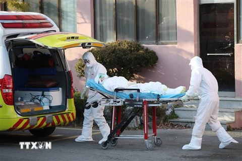 Nhân viên y tế chuyển bệnh nhân nhiễm COVID-19 lên xe cứu thương tại thành phố Daegu, Hàn Quốc ngày 21/2/2020. (Nguồn: AFP/TTXVN) 