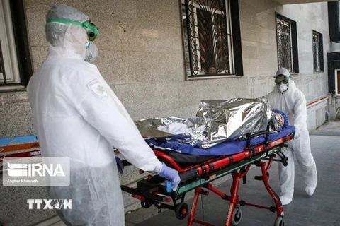 Nhân viên y tế chuyển bệnh nhân nhiễm COVID-19 tới bệnh viện tại Iran. (Nguồn: IRNA/TTXVN) 