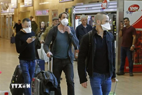 Hành khách tại sân bay quốc tế Ben Gurion, Israel, đeo khẩu trang để phòng tránh lây nhiễm COVID, ngày 27/2/2020. (Nguồn: AFP/TTXVN) 