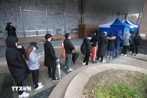Các nhân viên một trung tâm chăm sóc khách hàng bị nghi nhiễm COVID-19 xếp hàng chờ lấy mẫu xét nghiệm bệnh phẩm tại khu y tế dựng tạm ở Seoul, ngày 10/3/2020. (Nguồn: Yonhap/TTXVN) 
