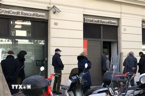Người dân xếp hàng bên ngoài một ngân hàng ở Rome ngày 10/3/2020, trong bối cảnh Italy tiến hành phong tỏa toàn quốc nhằm đối phó dịch COVID-19 lan rộng. (Nguồn: THX/TTXVN) 
