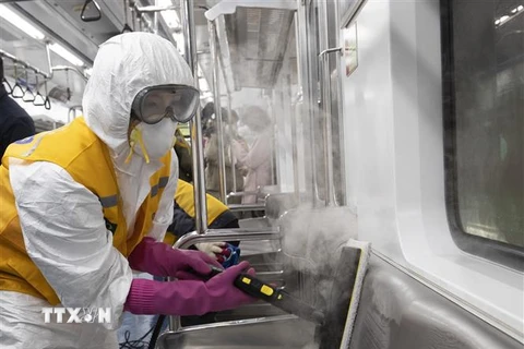 Nhân viên khử trùng tàu điện ngầm tại Seoul, Hàn Quốc, nhằm ngăn chặn sự lây lan của COVID-19 ngày 11/3/2020. (Nguồn: THX/TTXVN) 