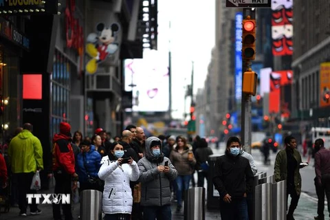 Người dân và du khách đeo khẩu trang phòng lây nhiễm COVID-19 tại khu vực Quảng trường Thời đại ở New York, Mỹ. (Nguồn: AFP/TTXVN) 