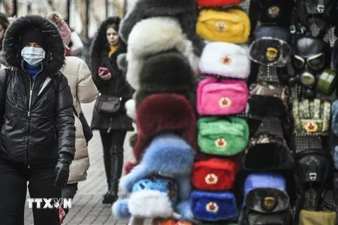 Người dân đeo khẩu trang phòng lây nhiễm dịch COVID-19 trên một đường phố ở Moskva, Nga. (Nguồn: AFP/TTXVN) 