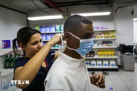 Người dân mua khẩu trang và dung dịch sát khuẩn tại một cửa hàng ở Caracas, Venezuela, ngày 13/3. (Nguồn: AFP/TTXVN) 
