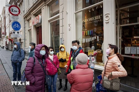 Người dân đeo khẩu trang nhằm ngăn chặn sự lây lan của dịch COVID-19 tại Amsterdam, Hà Lan ngày 17/3/2020. (Nguồn: AFP/TTXVN) 