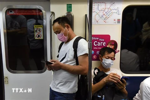 Người dân đeo khẩu trang phòng lây nhiễm COVID-19 tại Singapore, ngày 18/3/2020. (Nguồn: AFP/TTXVN) 