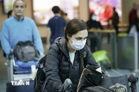 Hành khách đeo khẩu trang phòng lây nhiễm COVID-19 tại sân bay quốc tế Vancouver ở Richmond, Canada ngày 16/3/2020. (Nguồn: THX/TTXVN) 
