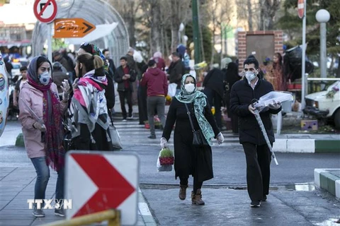 Người dân đeo khẩu trang để phòng tránh lây nhiễm COVID-19 tại Tehran, Iran, ngày 19/3/2020. (Nguồn: THX/TTXVN) 
