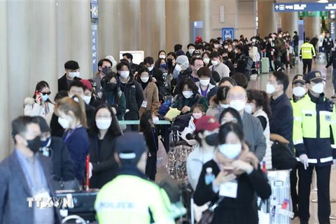 Hành khách đến từ Frankfurt, Đức, tại sân bay quốc tế Incheon, Hàn Quốc ngày 24/3/2020, chờ xe buýt để tới khu vực cách ly trong bối cảnh dịch COVID-19 lan rộng. (Nguồn: THX/ TTXVN) 