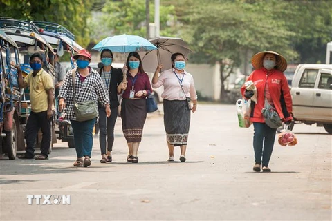 Người dân đeo khẩu trang phòng lây nhiễm COVID-19 tại Vientiane, Lào, ngày 23/3/2020. (Nguồn: THX/TTXVN) 