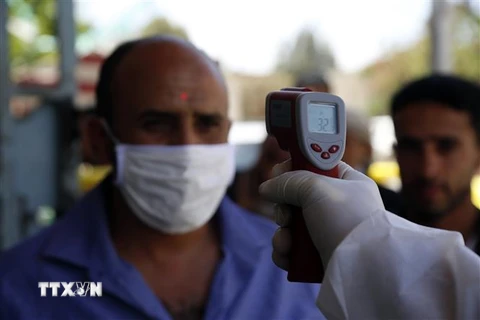 Nhân viên y tế kiểm tra nhiệt độ trước khi vào một bệnh viện ở Sanaa, Yemen, ngày 24/3. (Nguồn:THX/TTXVN) 