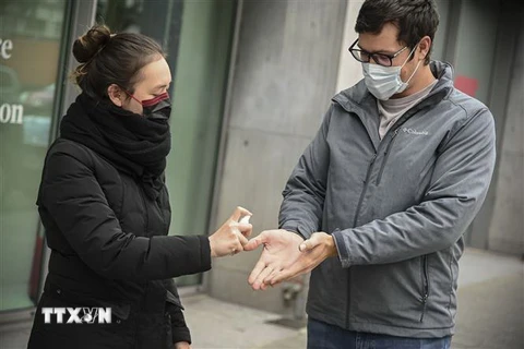 Người dân đeo khẩu trang và khử khuẩn để phòng dịch COVID-19 tại Brussels, Bỉ ngày 20/3/2020. (Nguồn: THX/TTXVN) 