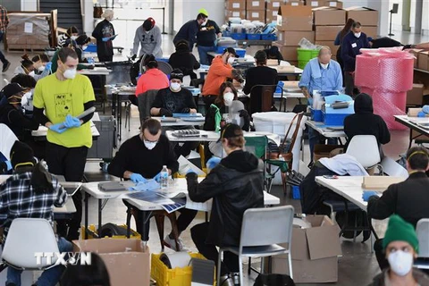 Nhân viên Hãng sản xuất công nghiệp thiết bị phòng hộ PPE chế tạo thiết bị phòng dịch COVID-19 để cung cấp cho các bệnh viện và cơ sở y tế, tại một khu xưởng của hải quân ở Brooklyn, New York (Mỹ) ngày 26/3/2020. (Nguồn: AFP/TTXVN) 