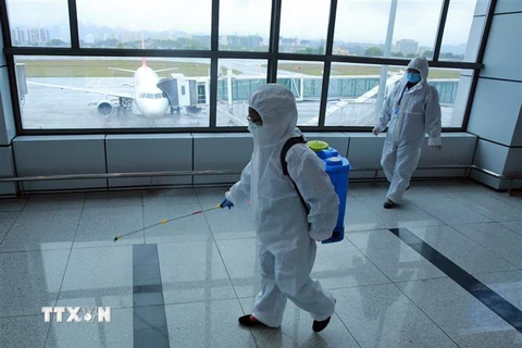 Nhân viên phun thuốc khử trùng tại sân bay ở tỉnh Hồ Bắc, Trung Quốc, ngày 29/3/2020 nhằm ngăn chặn sự lây lan của COVID-19. (Nguồn: THX/TTXVN) 
