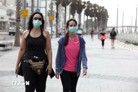 Người dân đeo khẩu trang phòng tránh lây nhiễm COVID-19 tại Tel Aviv, Israel, ngày 24/3/2020. (Nguồn: THX/TTXVN) 