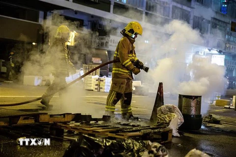 Nhân viên cứu hỏa dập các đám cháy do người biểu tình đốt tại Hong Kong, Trung Quốc, ngày 31/12/2019. (Nguồn: AFP/TTXVN) 