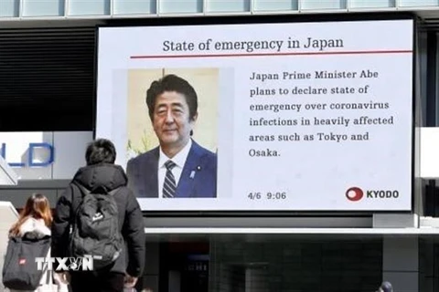 Người dân Nhật Bản theo dõi tin tức về việc Thủ tướng Shinzo Abe dự định sẽ ban bố tình trạng khẩn cấp do dịch COVID-19 ngày 6/4/2020. (Nguồn: Kyodo/TTXVN) 