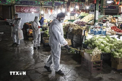 Tình nguyện viên phun thuốc khử trùng tại một khu chợ ở Tehran, Iran ngày 31/3/2020 nhằm ngăn chặn sự lây lan của COVID-19. (Nguồn: THX/TTXVN) 
