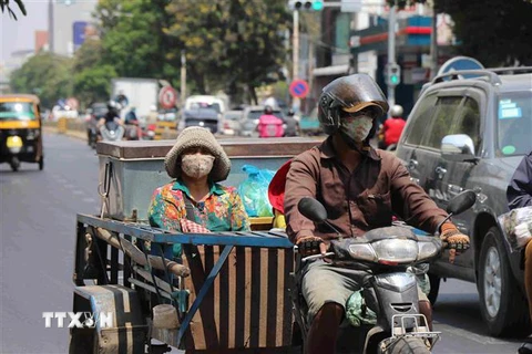 Người dân đeo khẩu trang phòng lây nhiễm COVID-19 trên một đường phố ở Phnom Penh, Campuchia, ngày 25/3/2020. (Nguồn: THX/TTXVN) 