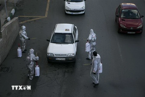 Nhân viên y tế Iran khử trùng các phương tiện giao thông trên đường phố thủ đô Tehran nhằm ngăn dịch COVID-19 lây lan, ngày 31/3/2020. (Nguồn: THX/TTXVN) 