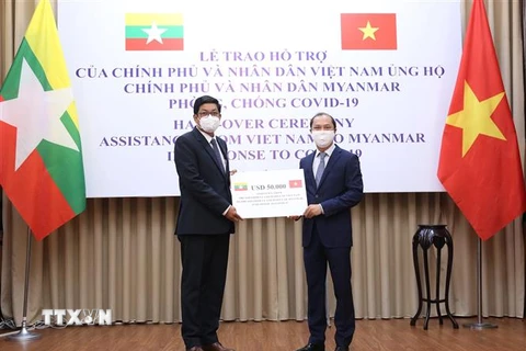Thứ trưởng Bộ Ngoại giao Nguyễn Quốc Dũng trao tiền hỗ trợ của Chính phủ và nhân dân Việt Nam cho Đại sứ Myanmar tại Việt Nam Kyaw Soe Win. (Ảnh: Dương Giang/TTXVN) 