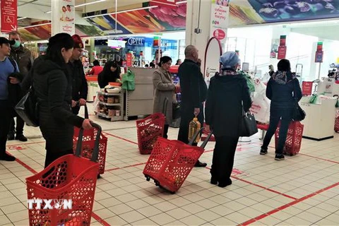 Xếp hàng giãn cách theo vạch kẻ trước quầy thanh toán tại một siêu thị ở thủ đô Moskva (Nga). (Ảnh: Duy Trinh/TTXVN) 