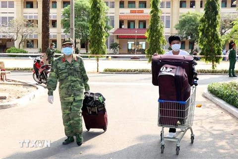 Các chiến sỹ trường Quân sự Quân khu 7 hỗ trợ vận chuyển đồ cho công dân đã hoàn thành xong thời gian cách ly y tế. (Ảnh: Xuân Khu/TTXVN) 