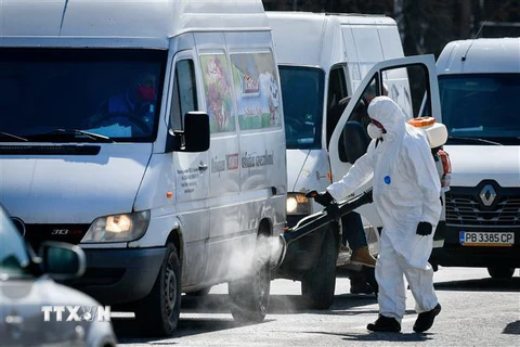 Nhân viên y tế phun thuốc khử trùng phòng lây nhiễm COVID-19 tại Bulgaria, ngày 18/3/2020. (Nguồn: AFP/TTXVN) 