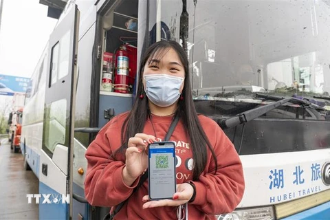 Một hành khách trình mã y tế để được phép đi lại tại trạm thu phí đường cao tốc ở Vũ Hán, Trung Quốc, ngày 24/3/2020. (Nguồn: THX/TTXVN) 