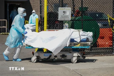 Nhân viên y tế chuyển thi thể bệnh nhân mắc COVID-19 ra nhà xác dã chiến bên ngoài bệnh viện Wyckoff ở Brooklyn, New York, Mỹ ngày 6/4/2020. (Nguồn: AFP/TTXVN) 