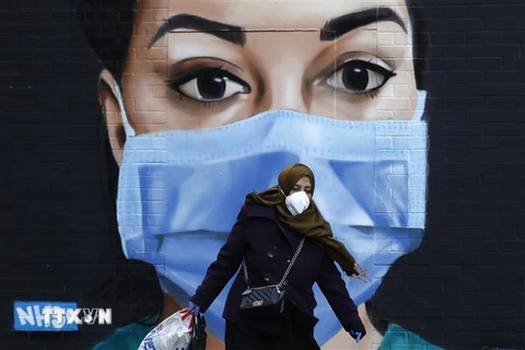 Người dân đeo khẩu trang phòng lây nhiễm COVID-19 tại London, Anh, ngày 22/4/2020. (Nguồn: AFP/TTXVN) 