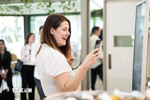 Khách hàng trải nghiệm một mẫu điện thoại thông minh của Samsung tại Sydney, Australia ngày 18/2/2020. (Nguồn: Yonhap/TTXVN) 