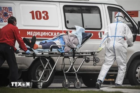 Nhân viên y tế chuyển bệnh nhân nhiễm COVID-19 tới bệnh viện ở Moskva, Nga, ngày 27/4/2020. (Nguồn: AFP/TTXVN) 