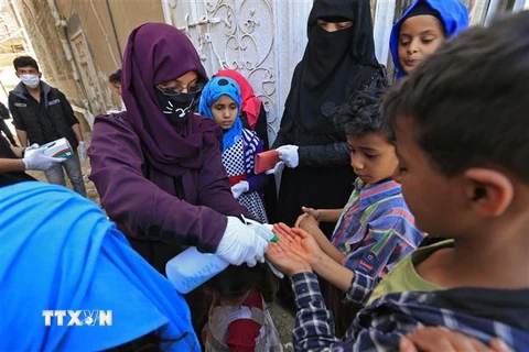Nhân viên tình nguyện phun dung dịch rửa tay khử trùng cho trẻ em nhằm ngăn chặn sự lây lan của dịch COVID-19 tại Sanaa, Yemen, ngày 30/3/2020. (Nguồn: AFP/TTXVN) 
