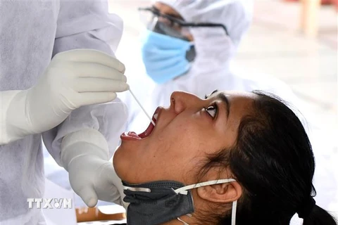 Nhân viên y tế lấy mẫu dịch xét nghiệm COVID-19 cho người dân tại New Delhi, Ấn Độ ngày 23/4/2020. (Nguồn: THX/TTXVN) 