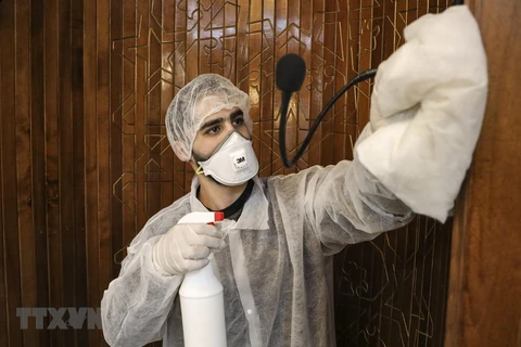 Công nhân phun thuốc khử trùng một nhà thờ nhằm ngăn dịch COVID-19 tại thành phố Hebron, Bờ Tây. (Ảnh: AFP/TTXVN) 