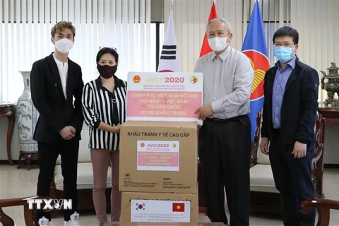 Đại sứ Nguyễn Vũ Tú trao tặng khẩu trang cho đại diện Hội người Việt Nam tại Hàn Quốc. (Ảnh: Mạnh Hùng/TTXVN) 