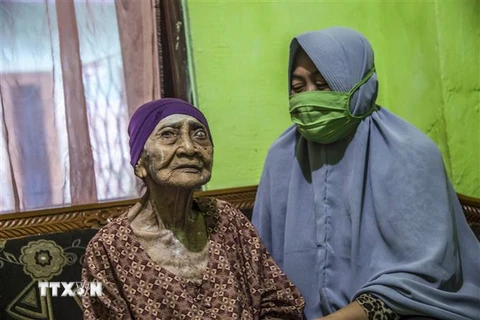 Cụ bà Kamtim (trái) tại nhà riêng ở Surabaya, Đông Java ngày 31/5/2020 sau khi được xuất viện khi khỏi bệnh COVID-19. (Nguồn: AFP/TTXVN) 