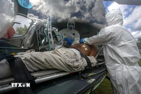 Nhân viên y tế chuyển bệnh nhân mắc COVID-19 tới bệnh viện ở Breves,Brazil. (Nguồn: AFP/TTXVN) 