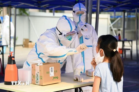 Nhân viên y tế lấy mẫu xét nghiệm COVID-19 cho người dân tại Bắc Kinh, Trung Quốc ngày 23/6/2020. (Nguồn: THX/TTXVN) 